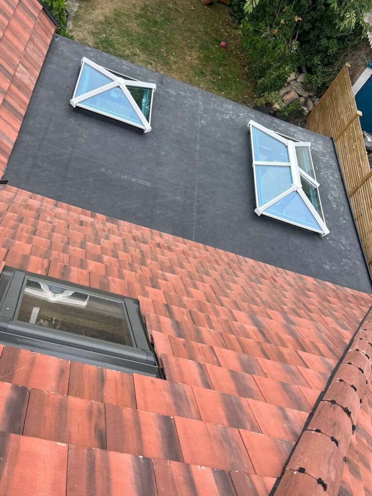 This is a photo taken from the roof ridge looking down a tiled pitched roof on to a flat roof. Works carried out by Gosport Roofing Repairs